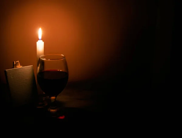 Natura morta da una candela un bicchiere di vino e un cavalletto — Foto Stock