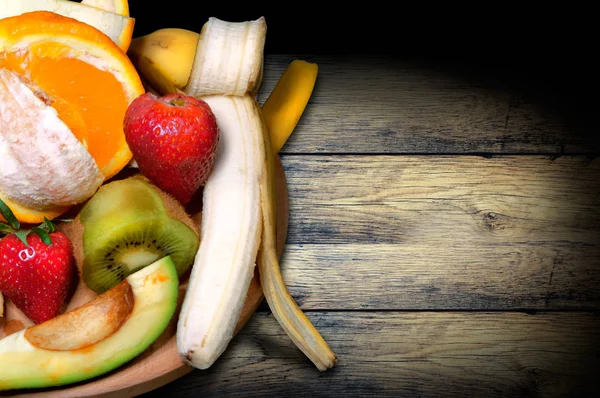 Vintage Board mit Obst, Orange, Kiwi, Banane, Erdbeere und Avocado, Draufsicht — Stockfoto