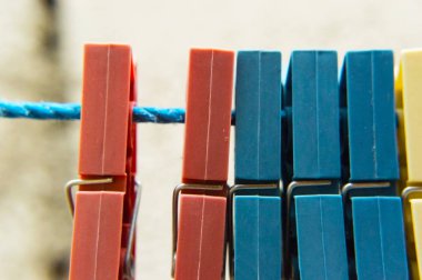 Mavi bir ip üzerinde farklı renklerde Clothespins.