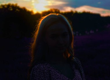 Romantik yaz günbatımı. Ortasında açık renk saçlı bir kız..