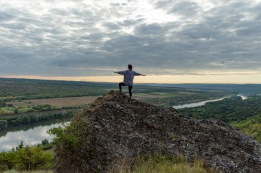 Yazın gün batımında Dinyester nehrinin üzerindeki uçurumun tepesindeki kız..