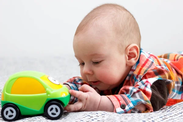 El niño está jugando con una camisa verde a cuadros de coche. —  Fotos de Stock