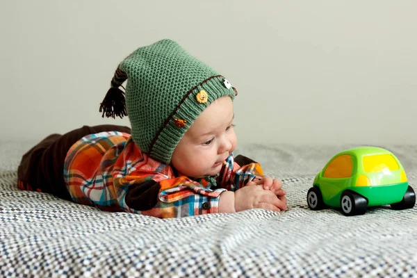 Мальчик играет в зеленую клетчатую рубашку, греческую шляпу — стоковое фото