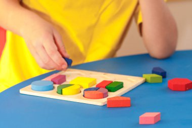 Ahşap renkli bulmaca ile oynayan çocuk, eğitim konsepti