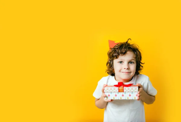Parti şapkalı yalnız çocuk elinde hediyeyle