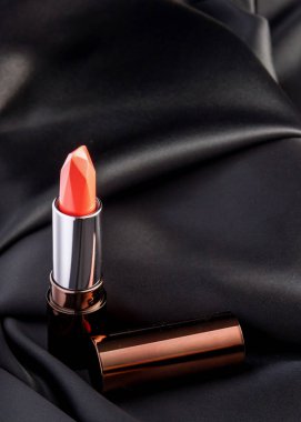 Kapalı kırmızı ruj siyah kumaş arka planında