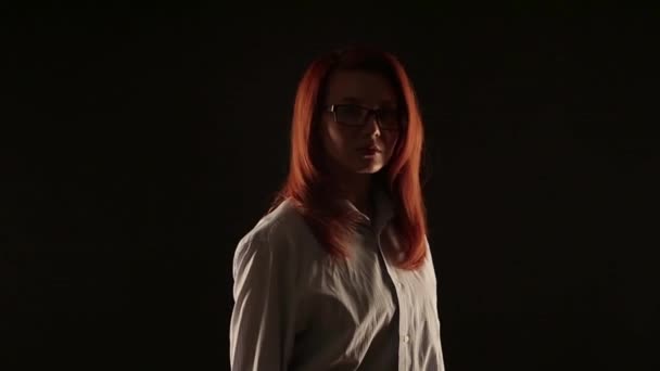 Красивая Девушка Рыжими Волосами Белой Рубашке Позирует Черном Фоне Перед — стоковое видео