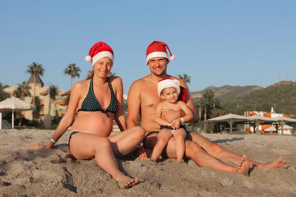 Familie Zwemkleding Rode Kerst Hoeden Zitten Het Zand Het Strand — Stockfoto