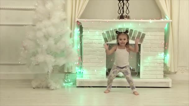 Маленька Дівчинка Двома Хвостами Танцює Смішно Фоні Каміна Ялинки — стокове відео