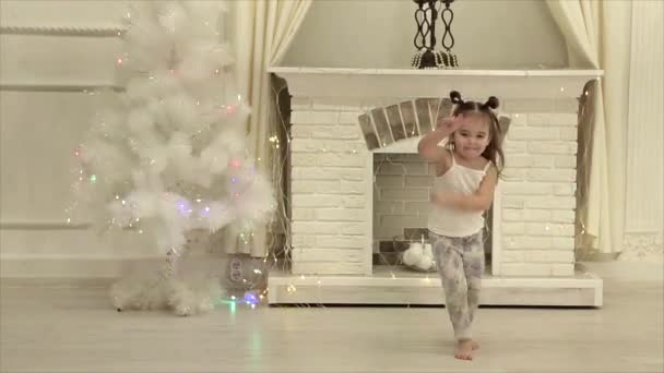 つの小さな女の子はツインテール暖炉とクリスマス ツリーの背景にダンス面白い — ストック動画