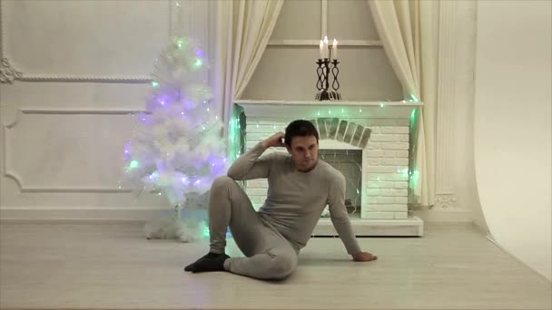 Man Zit Vloer Yoga Pose Achtergrond Van Open Haard Kerstboom — Stockvideo