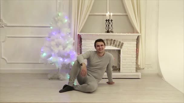 Man Zit Vloer Yoga Pose Achtergrond Van Open Haard Kerstboom — Stockvideo