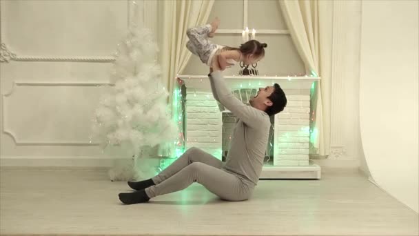 Man Sitter Golvet Yogaställning Bakgrunden Öppen Spis Julgran Garland — Stockvideo