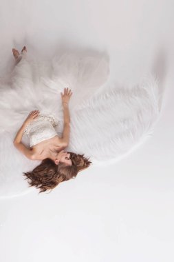 Melek kanatları beyaz arka plan üzerinde beyaz elbiseli kız. Angel-kadın