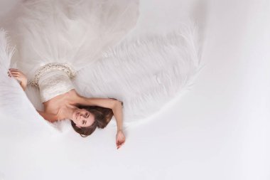 Melek kanatları beyaz arka plan üzerinde beyaz elbiseli kız. Angel-kadın