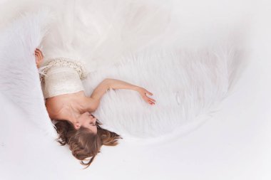 Melek kanatları beyaz arka plan üzerinde beyaz elbiseli kız. Angel-kadın