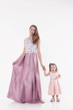 Anne ve çocuk beyaz bir arka plan üzerinde poz. Kadın ve kız pembe elbisesi oyunu