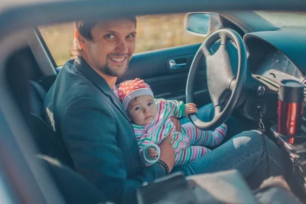 A little girl with her father pretends to drive a car. Concept photo of children education, learning , drive a car, funny, happy, play, happiness, car insurance