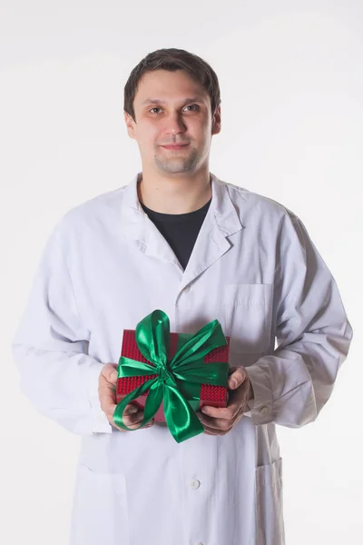 Mężczyzna Białą Szatę Posiada Pudełko Uśmiechający Się Lekarz Czerwonym Polu — Zdjęcie stockowe