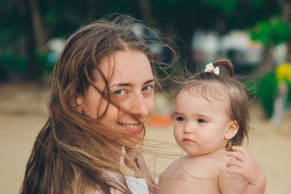 Bebek Annenin Kollarında Bir Çocuk Plaj Tropikal Bitki Örtüsü Arka — Stok fotoğraf