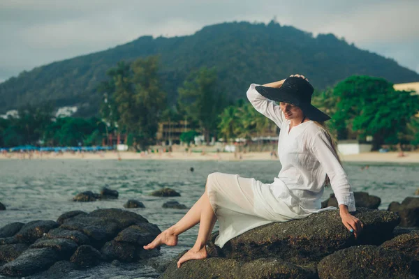 Uma Mulher Vestido Branco Chapéu Preto Siiting Nas Rochas Pelo — Fotografia de Stock