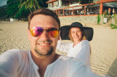 Bir erkek ve bir kadın portresi: bir çift sahilde bir selfie alır. Karı koca tatil