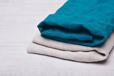 Beyaz arka plan üzerinde doğal kumaş kıyafetler kadar haddelenmiş. Giyim yakın çekim unsurları