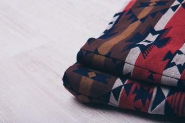 Beyaz arka plan üzerinde doğal kumaş kıyafetler kadar haddelenmiş. Giyim yakın çekim unsurları