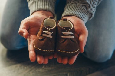 Bebeğin moda: erkekler ellerinde doğal malzemeler yalanların yapımı çocuk ayakkabı. Bağlama ile kahverengi süet veya nubuk patik