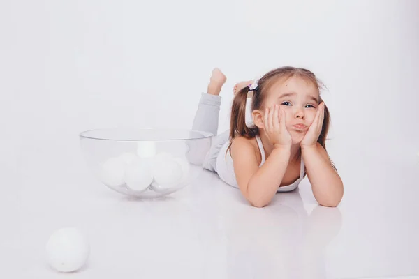 Маленька Дівчинка Лежить Підлозі Головою Піднятою Руками Білі Різдвяні Кульки — стокове фото