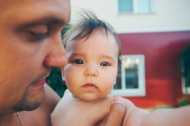 Baba bebek onun kollarında tutar. Küçük çocuklar, mutlu çocukluk, samimi bir aile babası eğitmek kavramı.