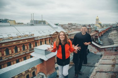 Çatının kenarında duran kadın ve erkek