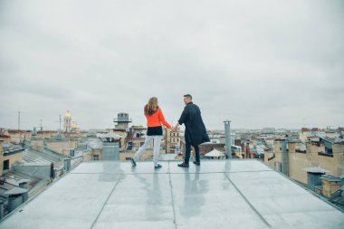 Çatının kenarında duran kadın ve erkek