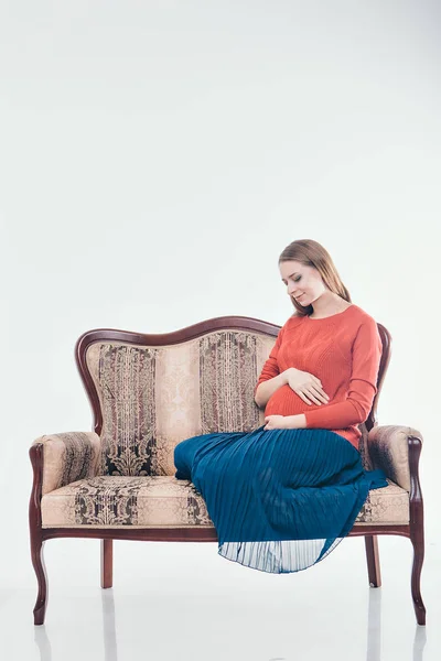 Schwangere Sitzt Auf Der Couch Vor Weißem Hintergrund — Stockfoto