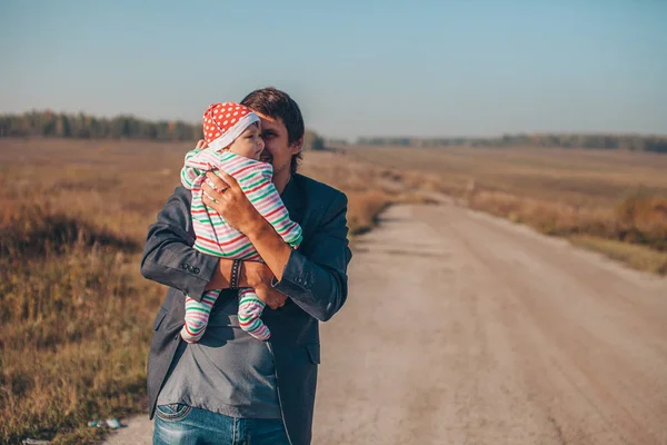 Muž Dítětem Náručí Silnici Uprostřed Pustiny — Stock fotografie