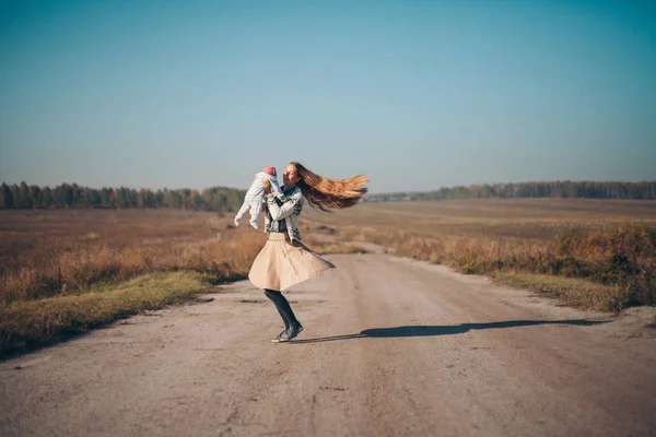 Yolun ortasında boş bir arazi üzerinde onun kollarında bir çocukla bir kadın