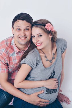 Aile portresi: hamile karısı kocası kucaklar. Bir erkek ve bir kadın yelek. hamile kaç aşk içinde
