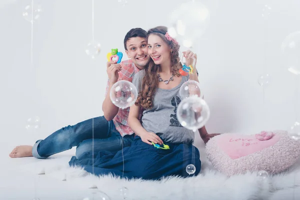 Mulher Grávida Homem Brincando Com Chocalho Chão Fundo Branco — Fotografia de Stock