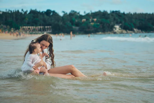 Matka s dítětem seděl na písku u moře. 8. března — Stock fotografie