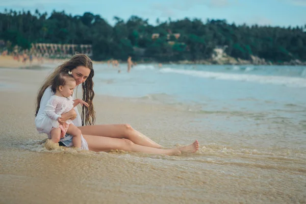 Matka s dítětem seděl na písku u moře. 8. března — Stock fotografie