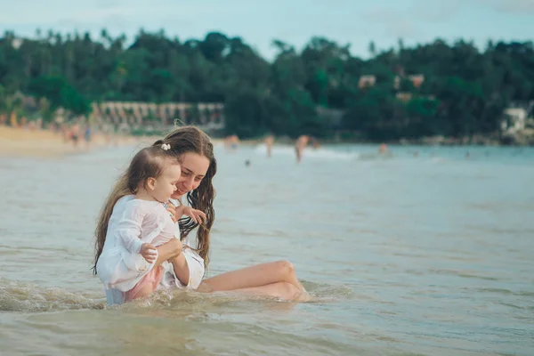 Matka s dítětem seděl na písku u moře. 8. března — Stock fotografie