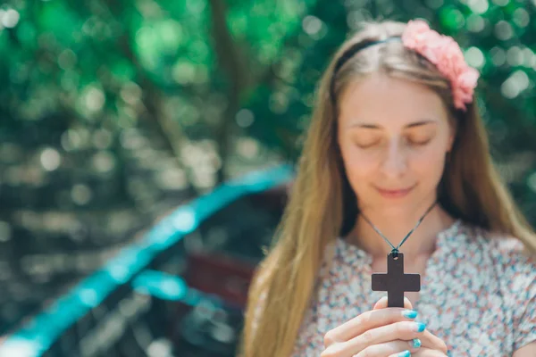 Krzyż w ręce zbliżenie dziewczyna, portret kobiety, niewyraźne — Zdjęcie stockowe