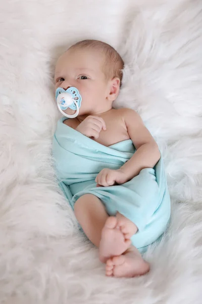 Bebé recién nacido dormido envuelto en una manta con un chupete en la boca. Salud, FIV —  Fotos de Stock