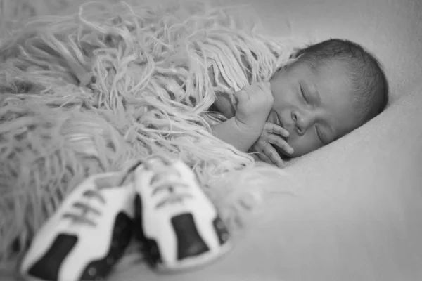 Bebé recién nacido y un par de zapatos de bebé — Foto de Stock