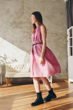 Güzel kız makyaj eve iç arka plan üzerinde siyah kemer ile pembe elbiseli olmadan