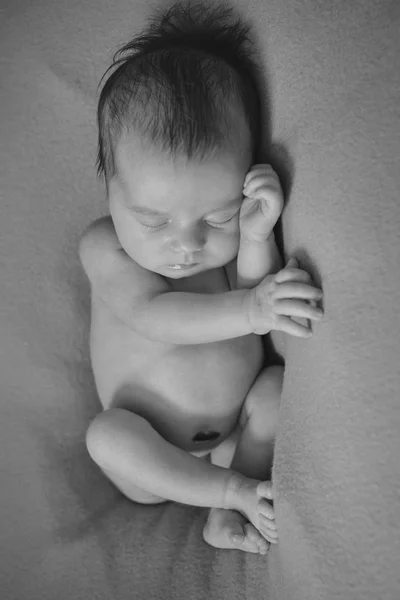 Bebé recién nacido desnudo durmiendo acurrucado en una pelota —  Fotos de Stock