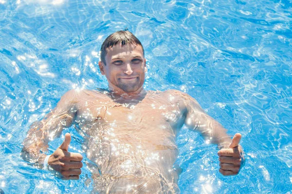 Hombre bronceado de vacaciones nadando en la piscina —  Fotos de Stock