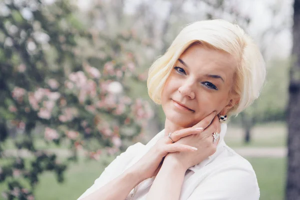 Stock image portrait of a beautiful blonde with short hair among flowers