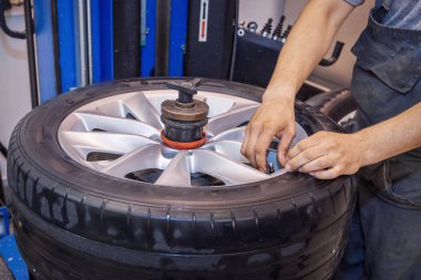 Araba tamir: tekerlek yerine portre. mekanik vidalama veya unscrewing araba tekerleği araba servisi Garage