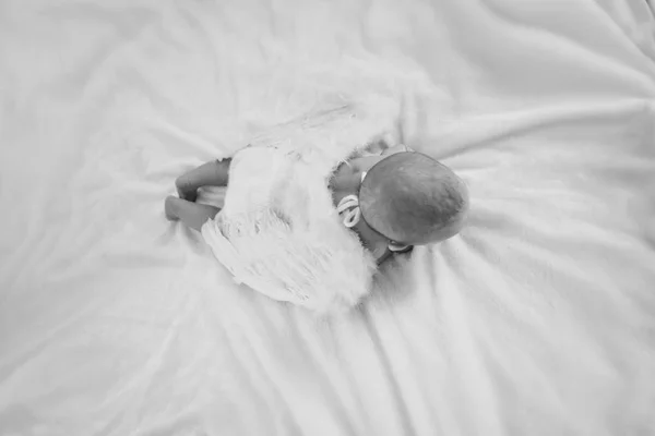 Boy with his mouth open is lying on a white background with wings behind his back. Angel Cupid looks up — Stock Photo, Image